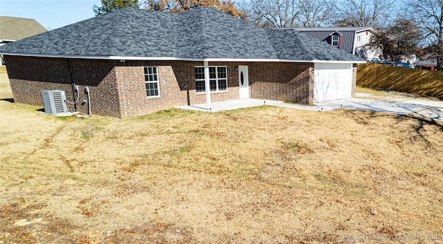 rear view of property featuring central AC unit and a yard