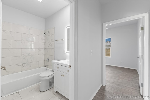 full bathroom featuring vanity, hardwood / wood-style floors, tiled shower / bath combo, and toilet