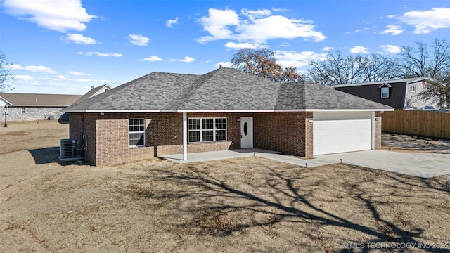 ranch-style home featuring cooling unit, a garage, a patio area, and a front lawn