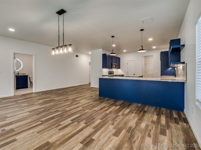 kitchen featuring hardwood / wood-style flooring, blue cabinets, and kitchen peninsula