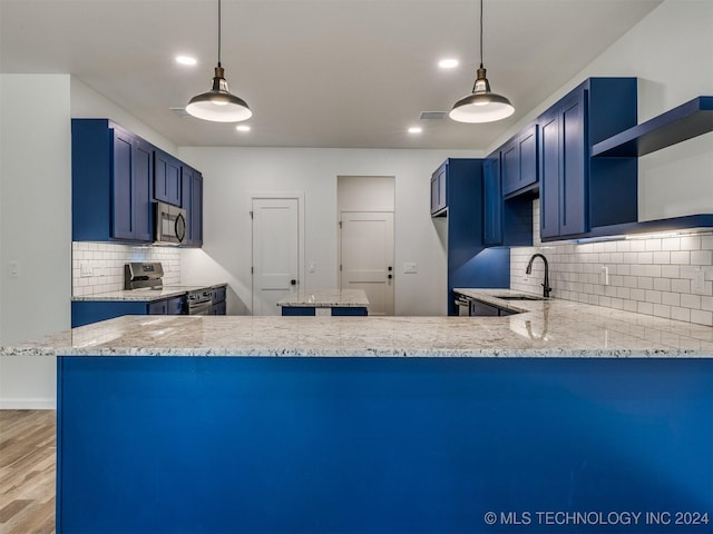 kitchen featuring blue cabinetry, kitchen peninsula, tasteful backsplash, and stainless steel appliances