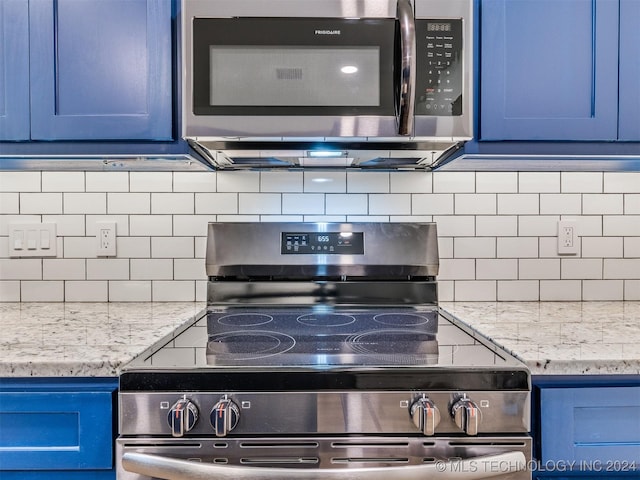 kitchen with backsplash, light stone counters, blue cabinets, and appliances with stainless steel finishes