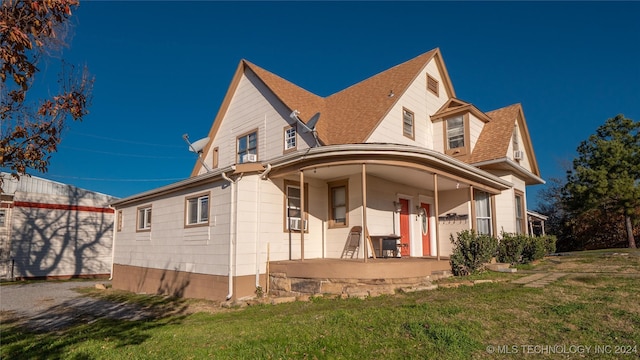 exterior space with covered porch, a front lawn, and cooling unit