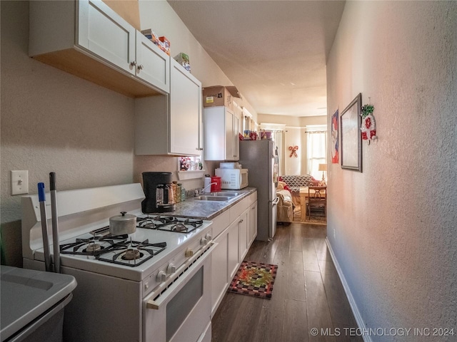 kitchen with dark hardwood / wood-style flooring, white appliances, and white cabinetry