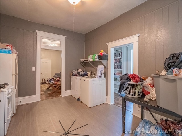 laundry area with washing machine and clothes dryer and hardwood / wood-style flooring