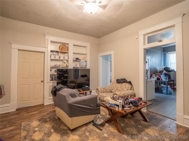 living room with built in shelves and dark hardwood / wood-style floors