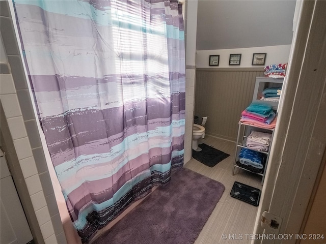 bathroom with a shower with curtain and toilet