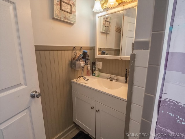 bathroom featuring wooden walls and vanity