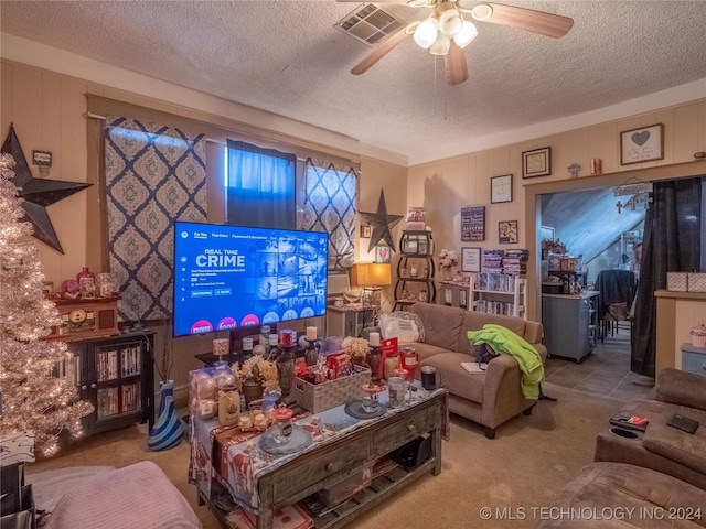 living room featuring tile patterned floors, ceiling fan, and a textured ceiling