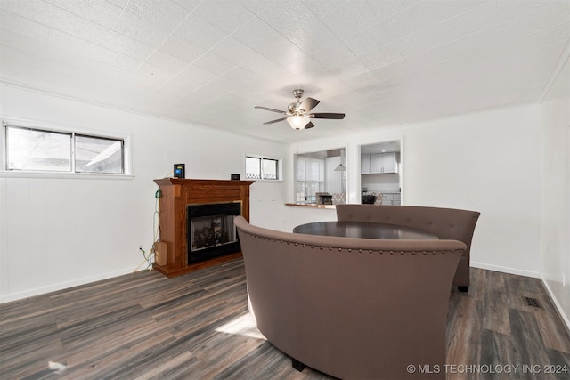 living room featuring ceiling fan, crown molding, and dark wood-type flooring