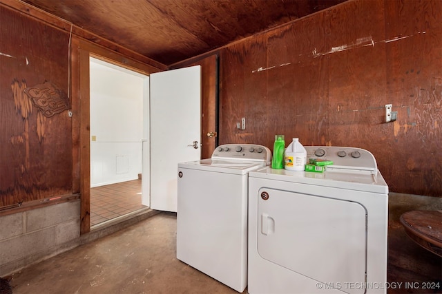 washroom with washer and clothes dryer, wood walls, and wooden ceiling