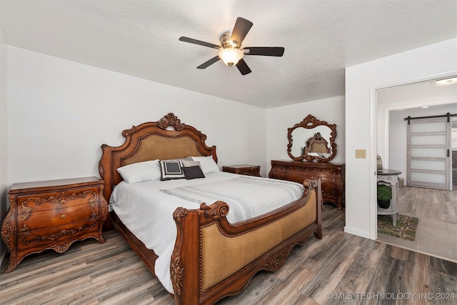 bedroom with ceiling fan, a textured ceiling, and hardwood / wood-style flooring