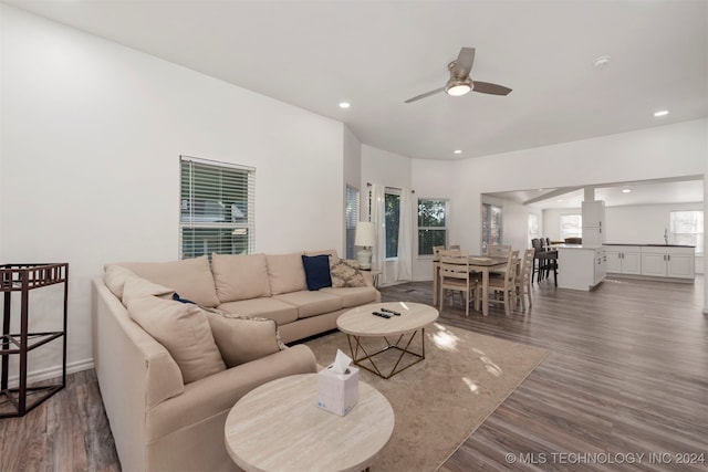 living room with dark hardwood / wood-style flooring and ceiling fan