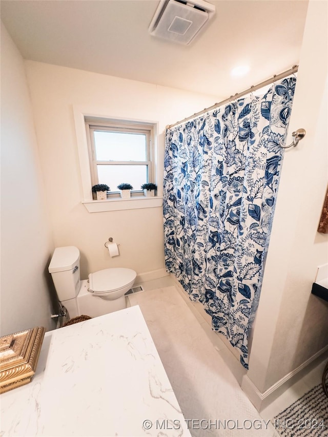 bathroom with a shower with shower curtain and toilet