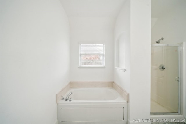 bathroom with lofted ceiling and plus walk in shower