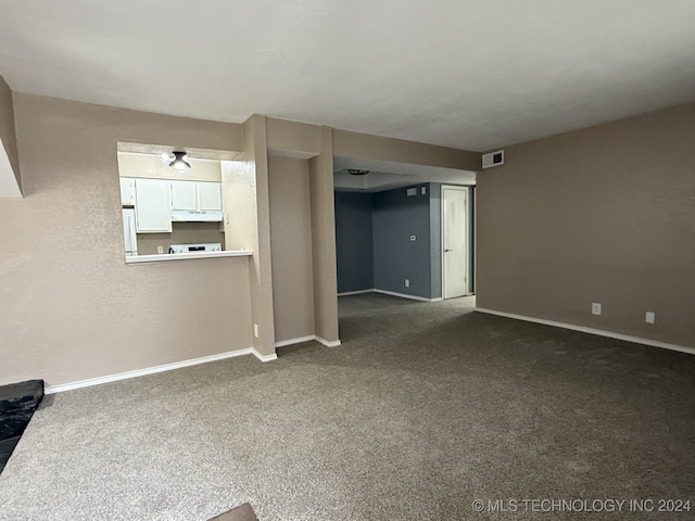 unfurnished living room featuring dark carpet