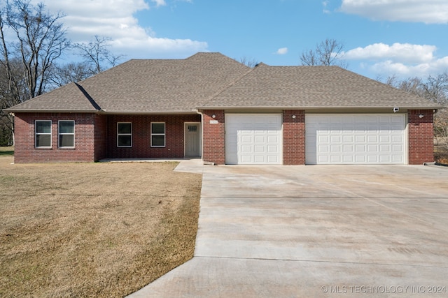 ranch-style house featuring a garage, roof with shingles, concrete driveway, and a front lawn