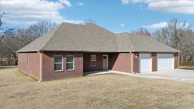 view of front of property featuring a garage and a front lawn