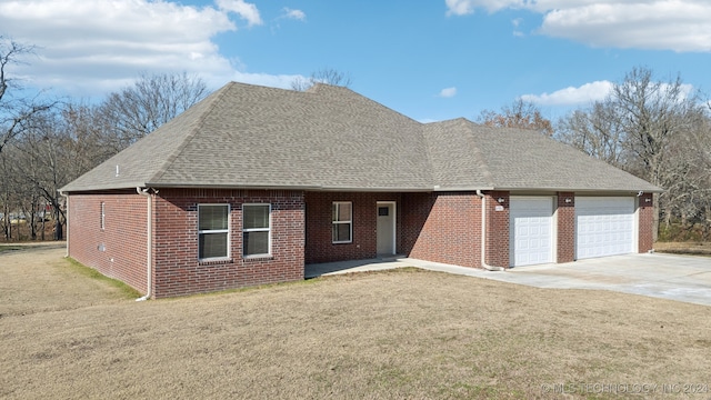 view of front of property with a front lawn, concrete driveway, an attached garage, a shingled roof, and brick siding