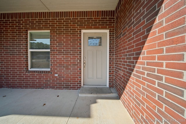 property entrance featuring brick siding