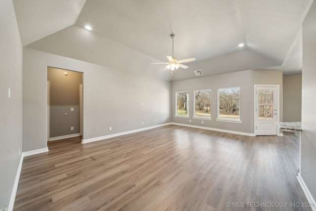 unfurnished living room with lofted ceiling, wood finished floors, and baseboards