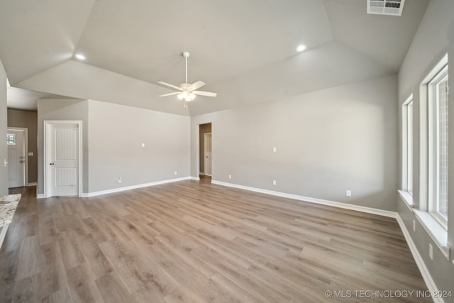 empty room with visible vents, baseboards, ceiling fan, lofted ceiling, and light wood-style floors