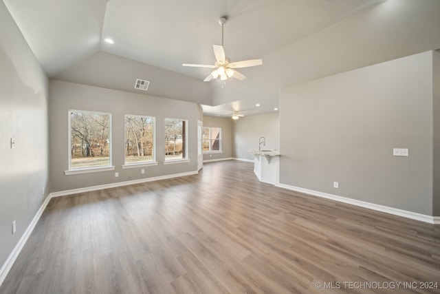 unfurnished living room featuring visible vents, a ceiling fan, wood finished floors, baseboards, and lofted ceiling