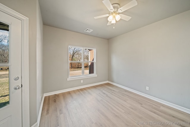 unfurnished room with ceiling fan, visible vents, baseboards, and wood finished floors