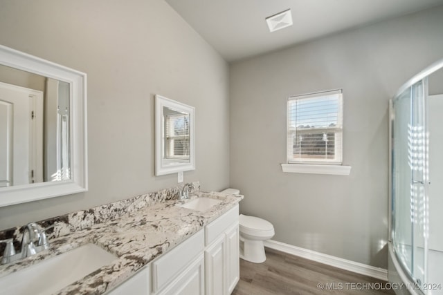 bathroom with a shower with door, toilet, wood finished floors, and a sink