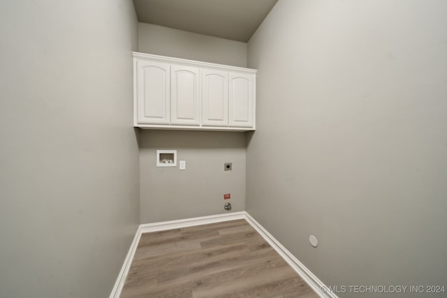 clothes washing area with light wood-style flooring, hookup for a gas dryer, cabinet space, hookup for an electric dryer, and hookup for a washing machine