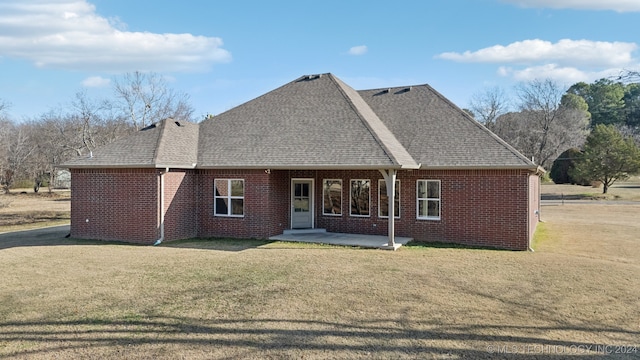 back of house with a yard, a patio area, brick siding, and a shingled roof