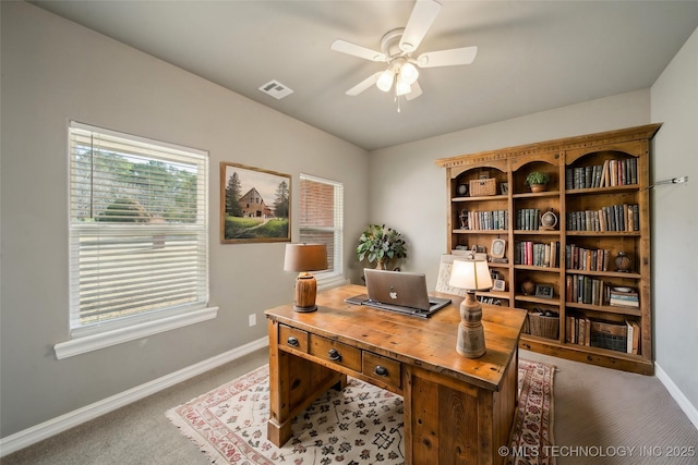 home office with carpet, visible vents, a ceiling fan, and baseboards