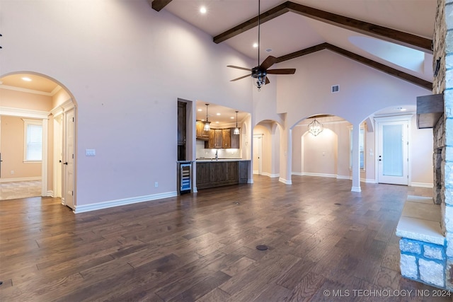 unfurnished living room with dark wood-type flooring, sink, beam ceiling, ceiling fan, and beverage cooler