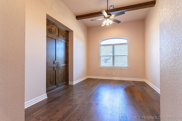 empty room with beamed ceiling, ceiling fan, and dark wood-type flooring