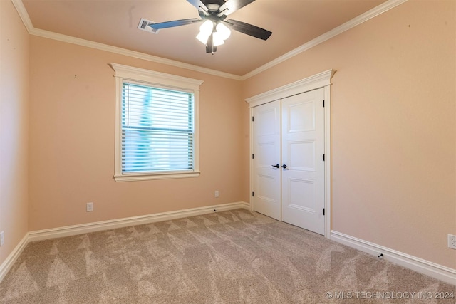 unfurnished bedroom with light carpet, crown molding, and a closet