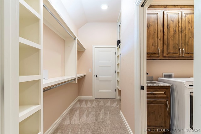 walk in closet with washer / clothes dryer, lofted ceiling, and light carpet