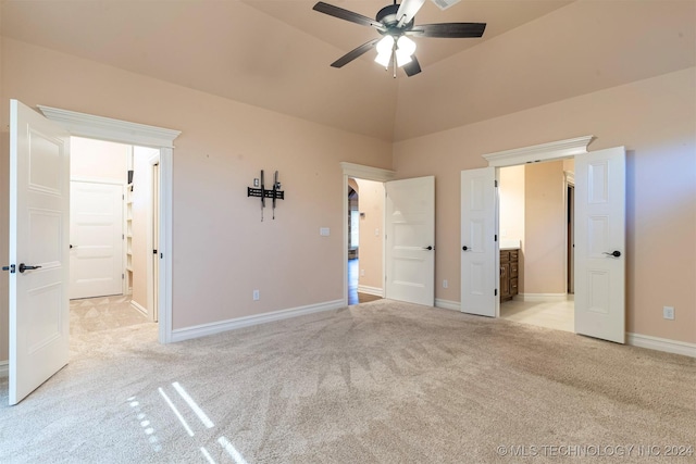 unfurnished bedroom with light carpet, vaulted ceiling, and ensuite bathroom