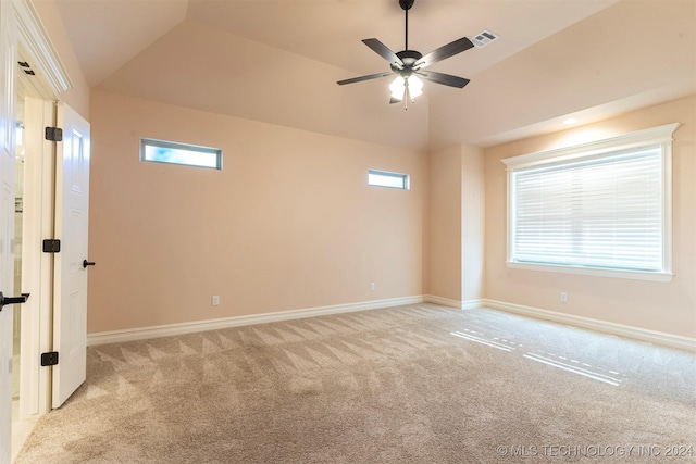 spare room featuring light carpet, a wealth of natural light, ceiling fan, and vaulted ceiling