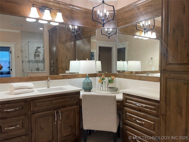 bathroom with an enclosed shower, vanity, and a chandelier