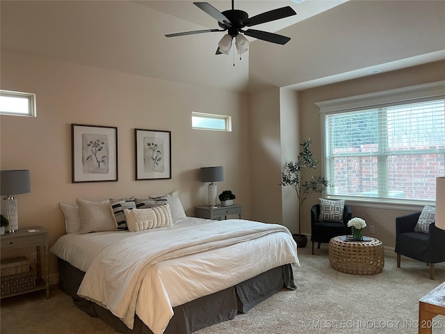 carpeted bedroom featuring ceiling fan, vaulted ceiling, and multiple windows