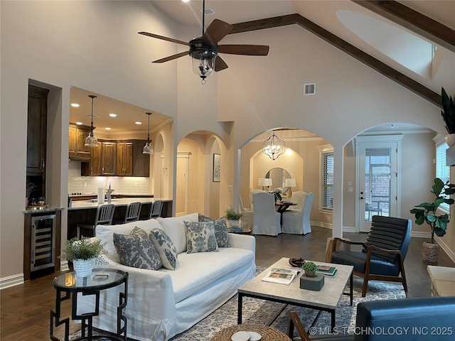 living room featuring wine cooler, high vaulted ceiling, dark hardwood / wood-style flooring, and ceiling fan with notable chandelier