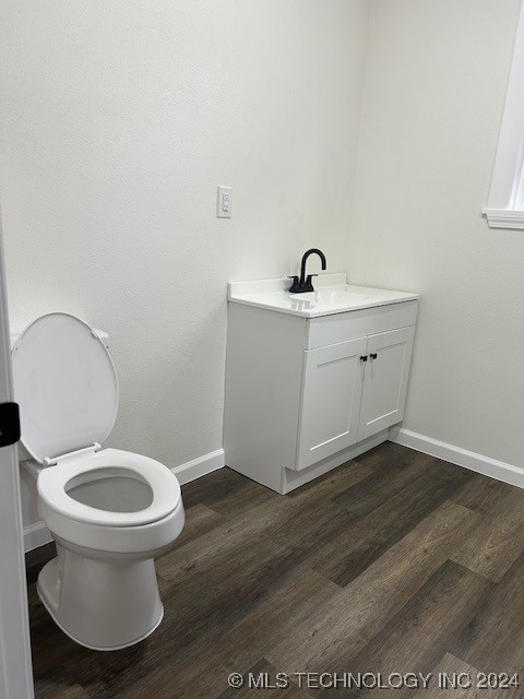 bathroom with vanity, toilet, and wood-type flooring