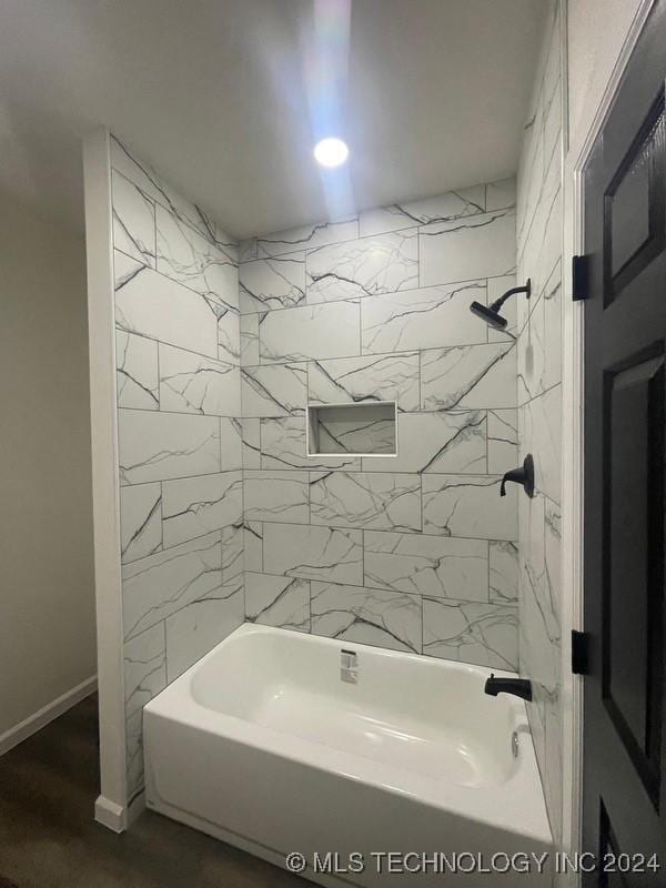 bathroom with hardwood / wood-style floors and tiled shower / bath combo