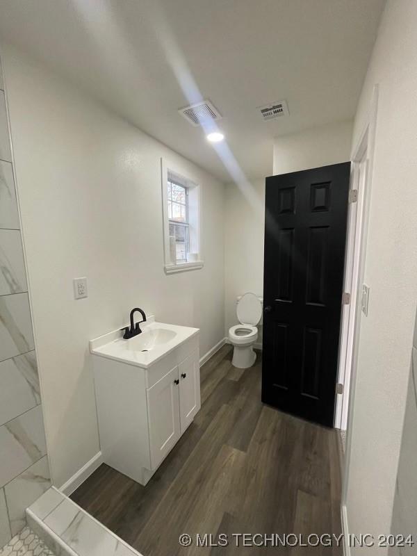 bathroom with vanity, hardwood / wood-style flooring, and toilet