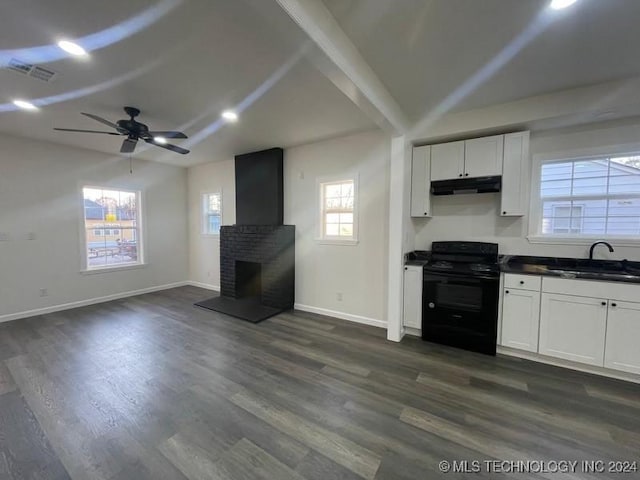 kitchen featuring a brick fireplace, black range with electric cooktop, white cabinetry, and sink