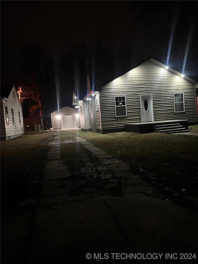 view of front of home featuring a garage and an outbuilding