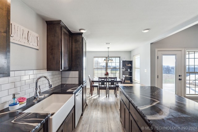 kitchen featuring pendant lighting, backsplash, sink, dark brown cabinets, and light hardwood / wood-style floors