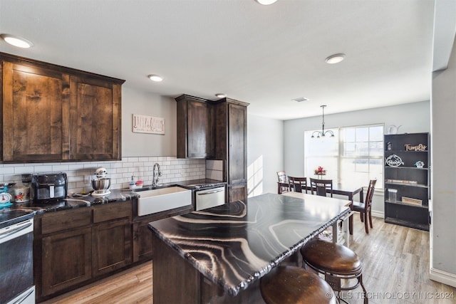 kitchen featuring stainless steel range with electric stovetop, sink, light hardwood / wood-style flooring, decorative backsplash, and dark brown cabinets