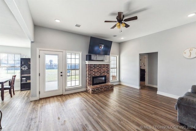 living room with ceiling fan, a fireplace, and dark wood-type flooring