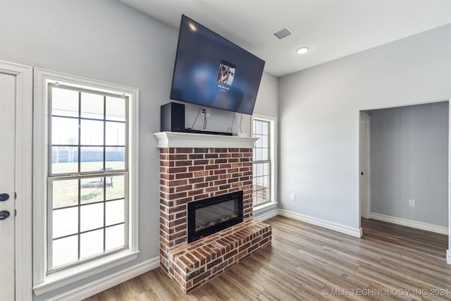 living room featuring hardwood / wood-style floors and a brick fireplace